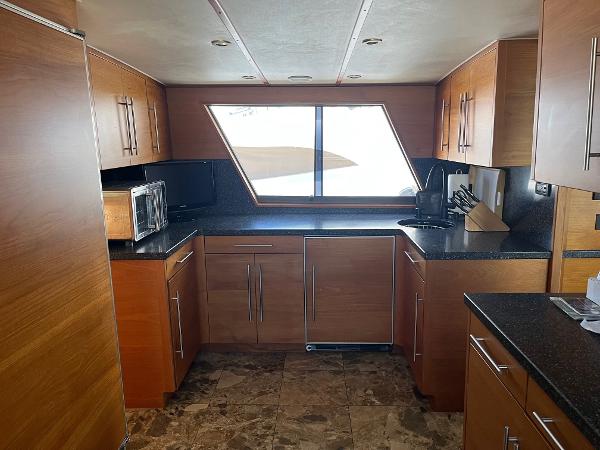 Slide: The Image of 1986 Hatteras 70' Cockpit Motor Yacht kitchen with modern appliances and wood cabinetry. - 14