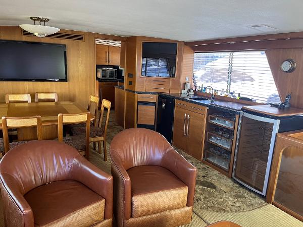 Slide: The Image of 1986 Hatteras 70' Cockpit Motor Yacht interior with leather chairs, dining area, and kitchen. - 16