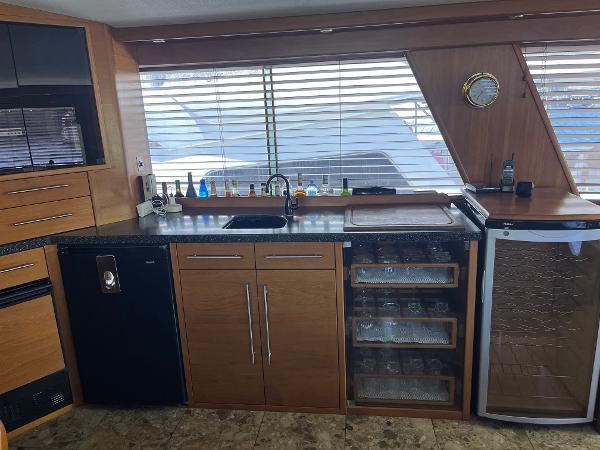 Slide: The Image of Modern kitchen area in 1986 Hatteras 70' Cockpit Motor Yacht with black countertops. - 18