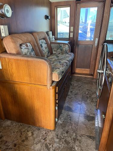 Slide: The Image of Interior of 1986 Hatteras 70' Cockpit Motor Yacht with wooden furnishings and cushioned seating. - 27