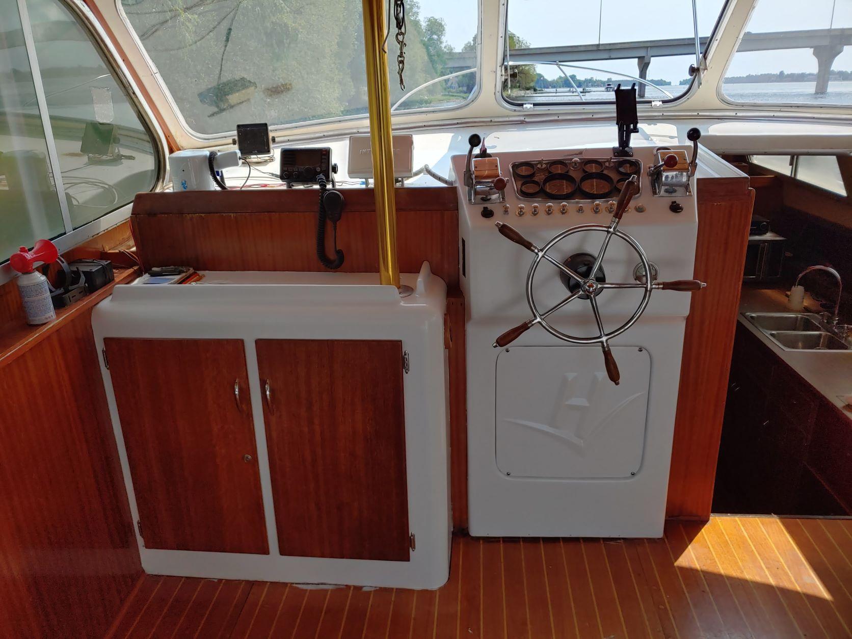 Slide: The Image of 1961 Hatteras Convertible boat helm with wooden cabinetry and steering wheel. - 10