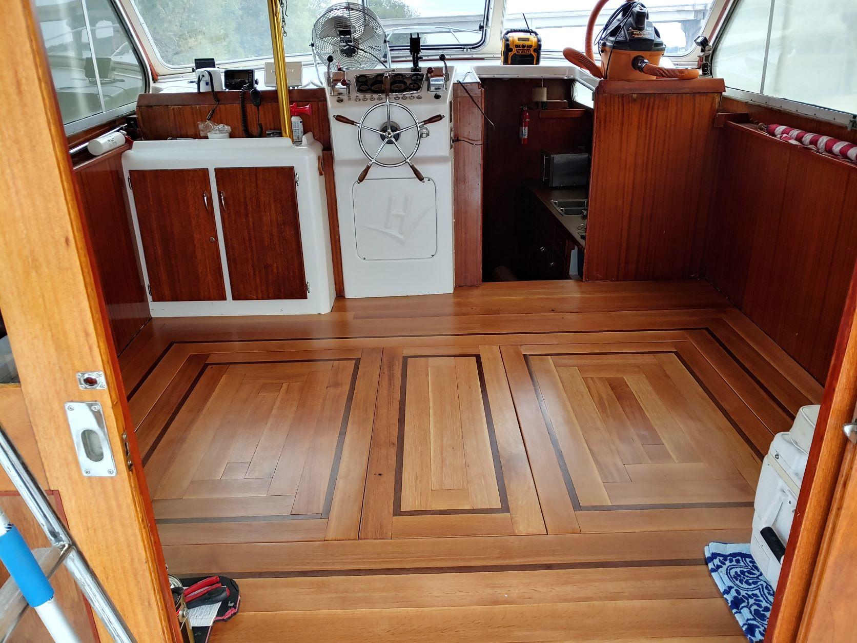 Slide: The Image of Interior of a 1961 Hatteras Convertible boat with polished wooden flooring. - 11