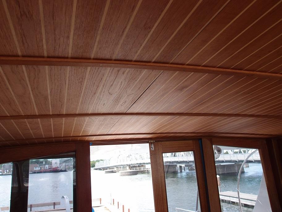 Slide: The Image of Wooden interior ceiling of a 1961 Hatteras Convertible boat with water view. - 14