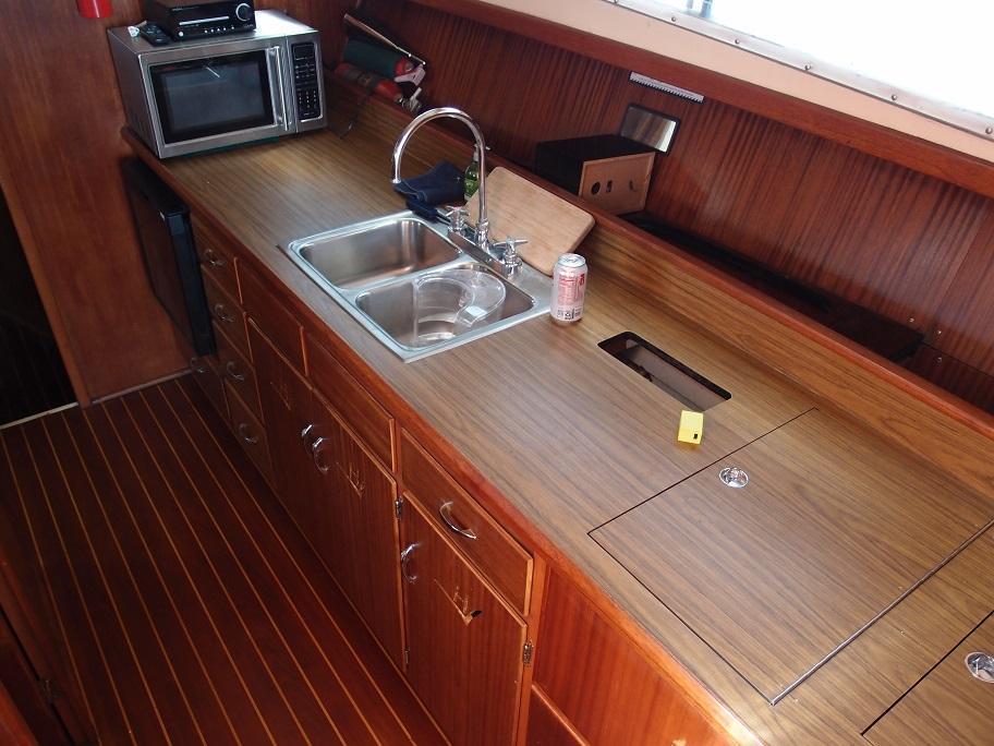 Slide: The Image of 1961 Hatteras Convertible yacht kitchen with wooden cabinetry, sink, and microwave. - 15