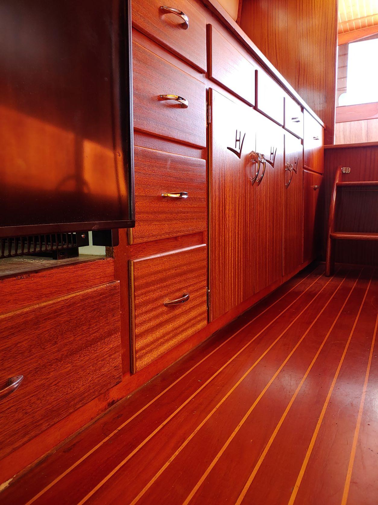Slide: The Image of Interior of 1961 Hatteras Convertible boat with polished wooden cabinets and flooring. - 17