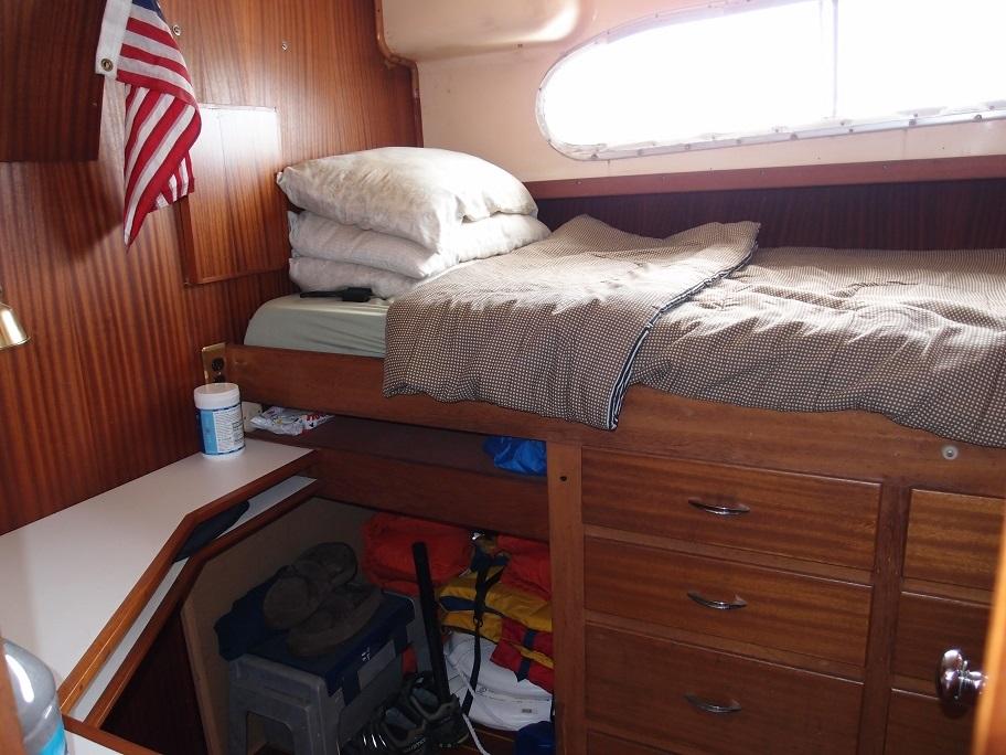 Slide: The Image of Cozy cabin interior of a 1961 Hatteras Convertible boat with bed and storage. - 19