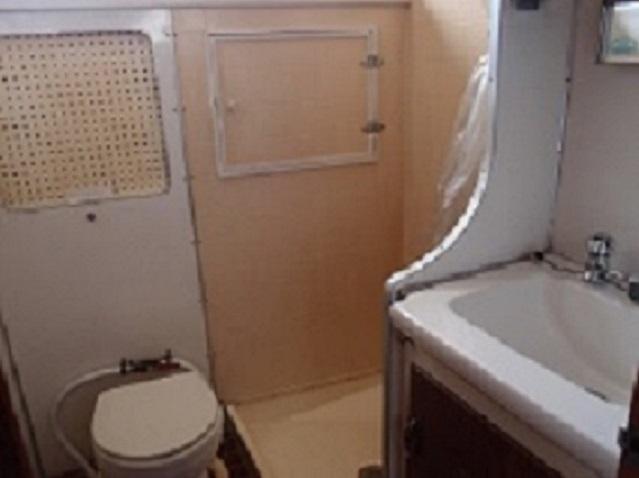 Slide: The Image of 1961 Hatteras Convertible boat bathroom with toilet, sink, and shower. - 21