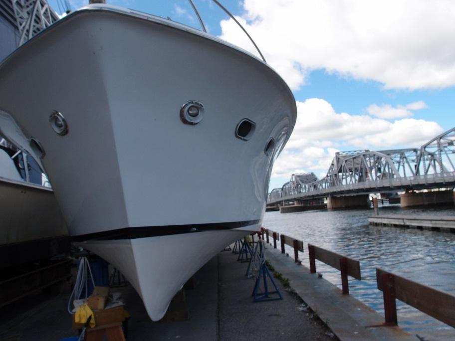 Slide: The Image of 1961 Hatteras Convertible boat docked near a bridge on a sunny day. - 3
