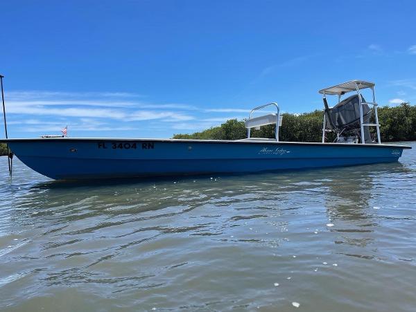 Slide: The Image of 2009 Hell's Bay WATERMAN boat on calm water under clear blue sky. - 0