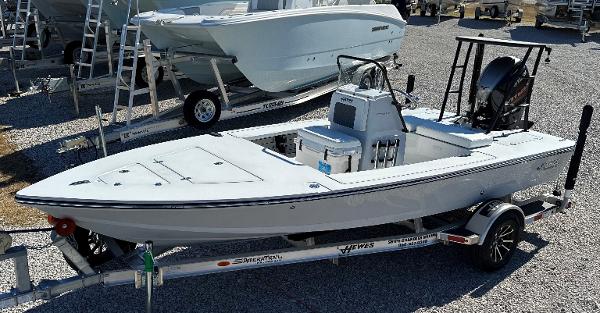 Slide: The Image of 2024 Hewes 18 Redfisher boat on a trailer in a dealership lot. - 10