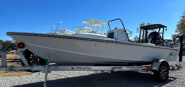 Slide: The Image of 2024 Hewes 18 Redfisher boat on a trailer in a sunny outdoor setting. - 9