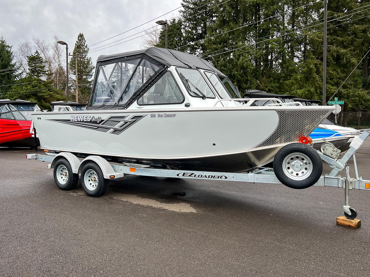 Slide: The Image of 2023 Hewescraft 190 Sea Runner boat on EZ Loader trailer in parking lot. - 1