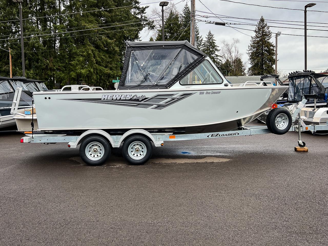 Slide: The Image of 2023 Hewescraft 190 Sea Runner boat on EZ Loader trailer in parking lot. - 2