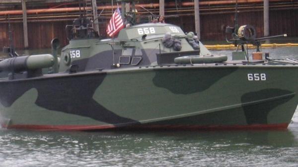 Slide: The Image of 1945 Higgins PT boat with camouflage paint and American flag on water. - 0