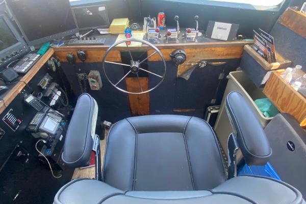 Slide: The Image of 1945 Higgins PT boat cockpit with steering wheel, control panels, and navigation equipment. - 11