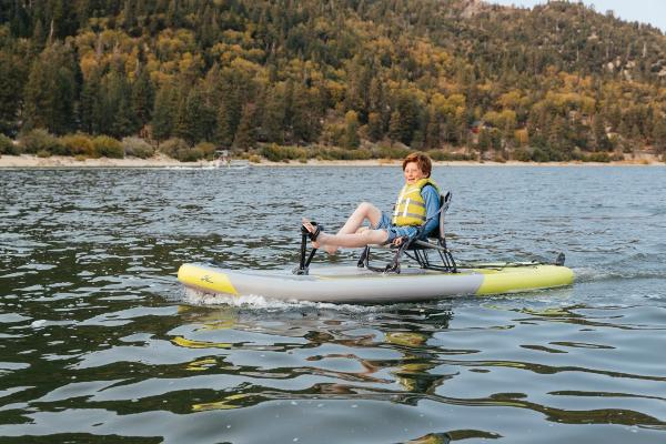 Slide: The Image of Person enjoying a ride on a 2023 Hobie iTrek 9 Ultralight inflatable kayak on a lake. - 1