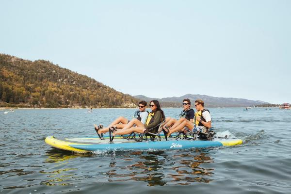 Slide: The Image of Four people enjoying a ride on a 2023 Hobie iTrek Fiesta pedal kayak. - 1