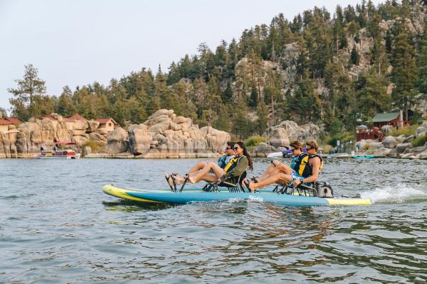 Slide: The Image of 2023 Hobie iTrek Fiesta on a scenic lake with four people pedaling. - 3