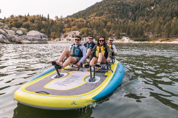 Slide: The Image of Four people enjoying a ride on a 2022 Hobie Mirage Itrek Fiesta on a lake. - 1