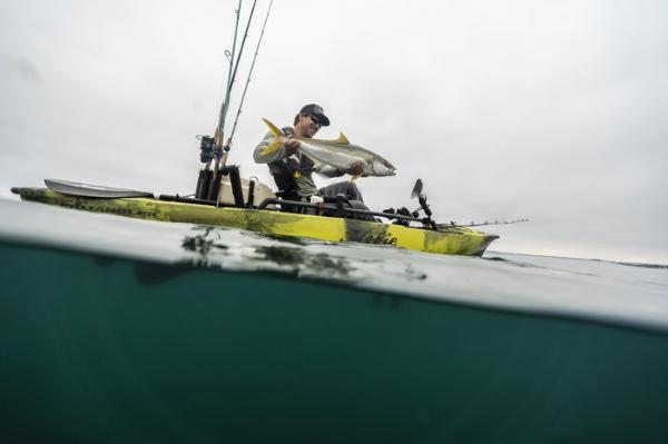 Slide: The Image of Angler on Hobie Mirage Pro Angler 12 kayak with 360 Drive Technology holding a fish, 2023 model. - 3