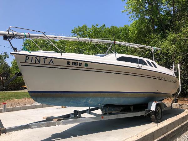 Slide: The Image of 1998 Hunter 240 sailboat on trailer, named "Pinta," parked outdoors. - 0