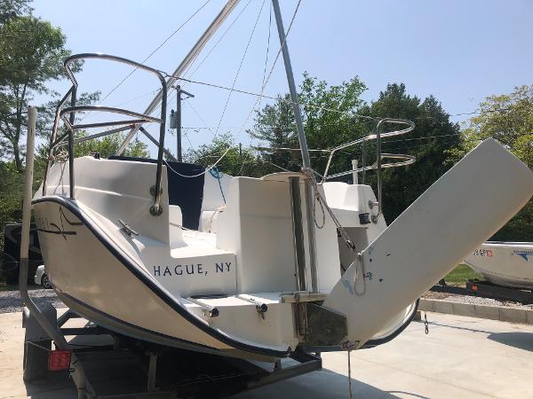 Slide: The Image of 1998 Hunter 240 sailboat on trailer, located in Hague, NY, with trees in the background. - 2