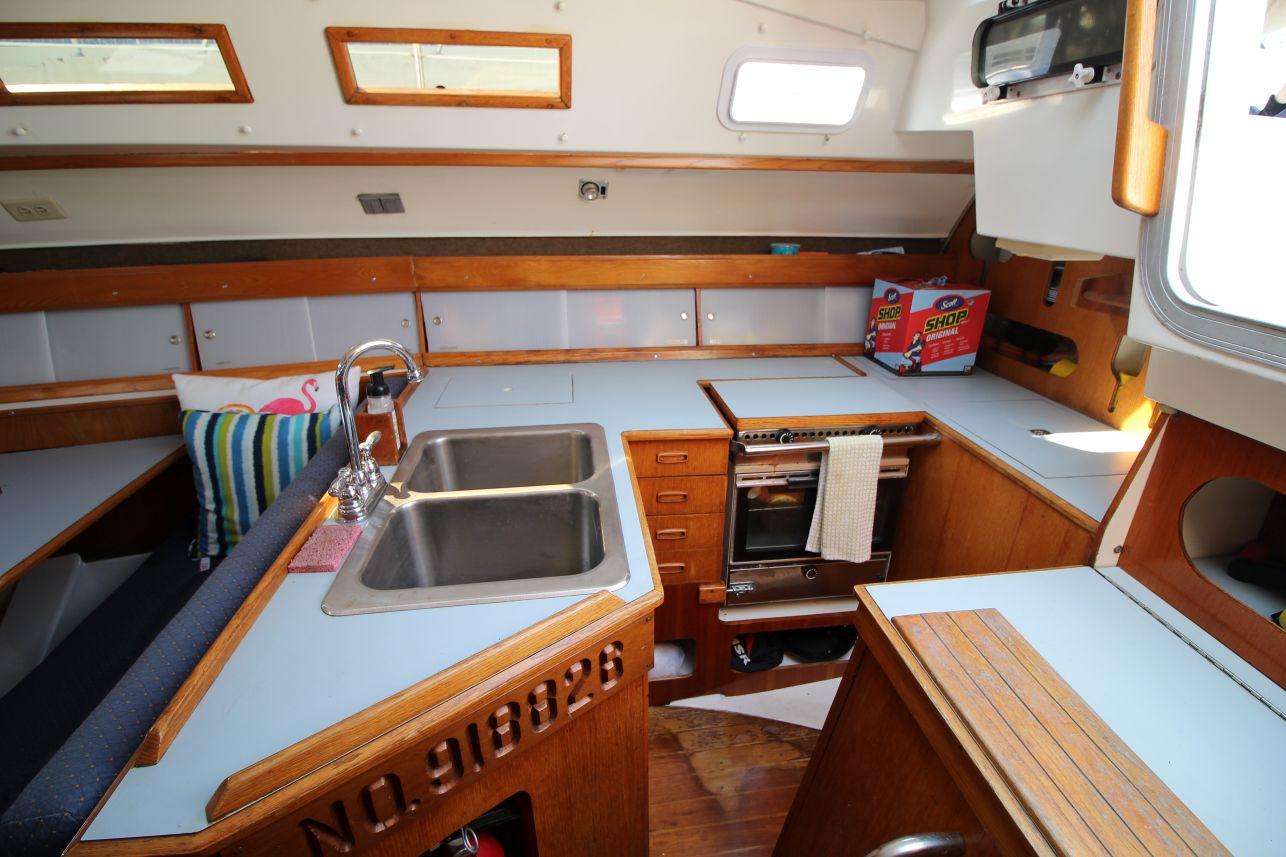 Slide: The Image of Interior of 1987 Hunter 34 sailboat kitchen with sink, stove, and storage. - 13