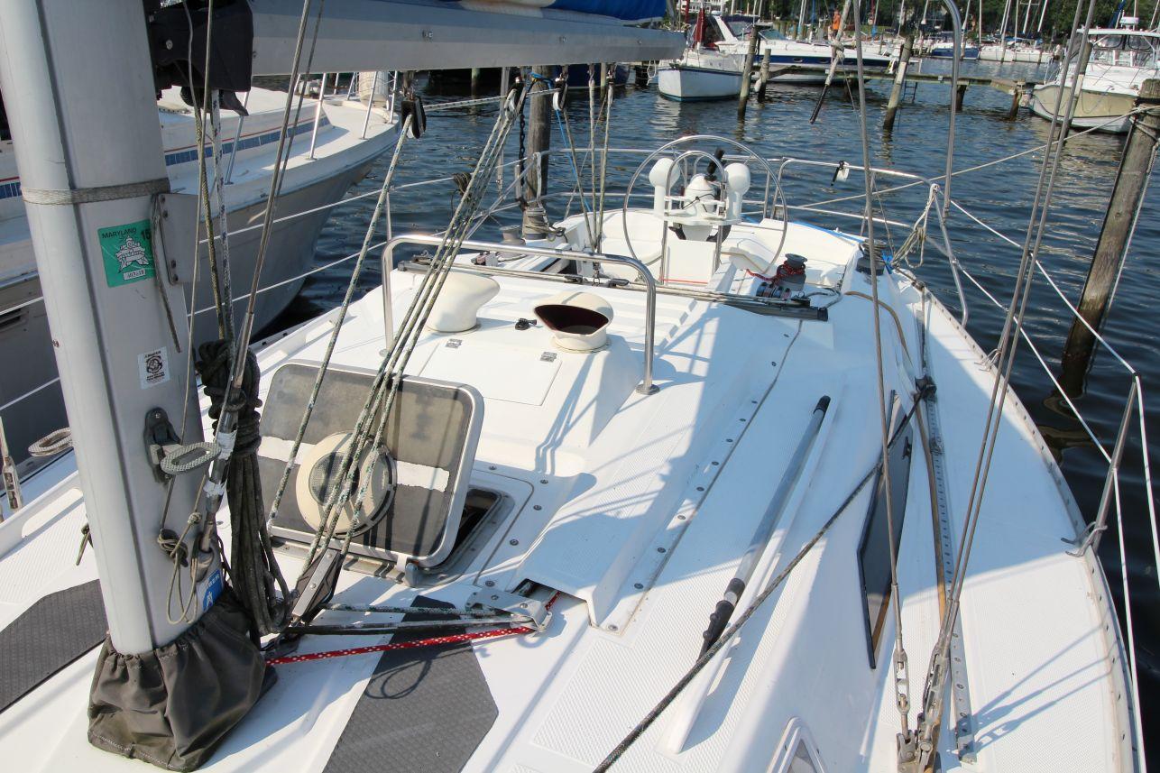 Slide: The Image of 1987 Hunter 34 sailboat deck view, featuring rigging and steering wheel at marina. - 8