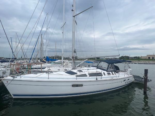Slide: The Image of 2000 Hunter 410 sailboat docked at marina under cloudy sky. - 0