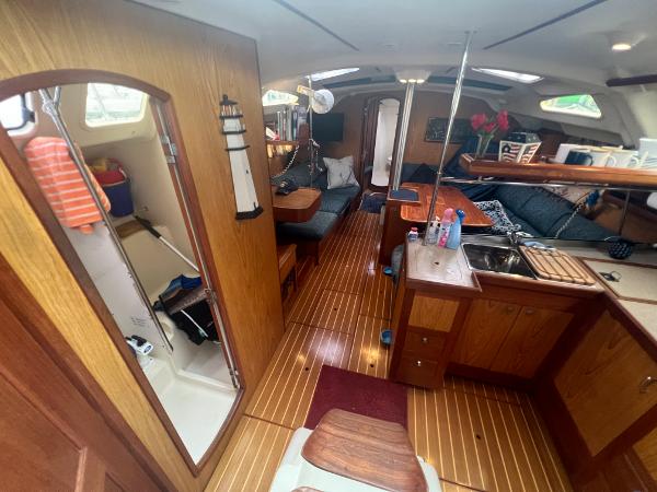Slide: The Image of Interior of a 2000 Hunter 410 sailboat with wood finishes and cozy seating area. - 27