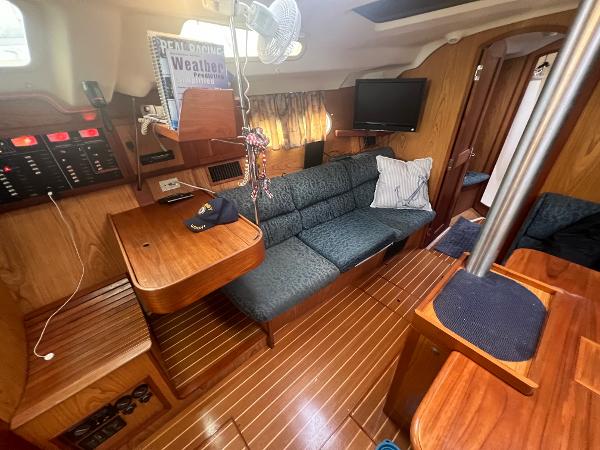Slide: The Image of Interior of a 2000 Hunter 410 sailboat with wood finish and cozy seating area. - 29