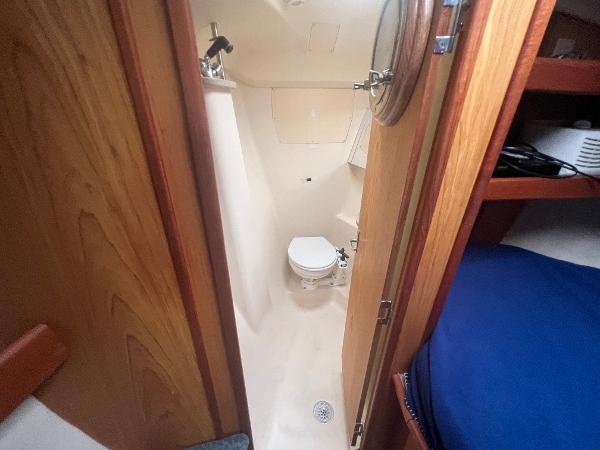 Slide: The Image of Compact bathroom in a 2000 Hunter 410 sailboat, featuring a toilet and shower. - 33