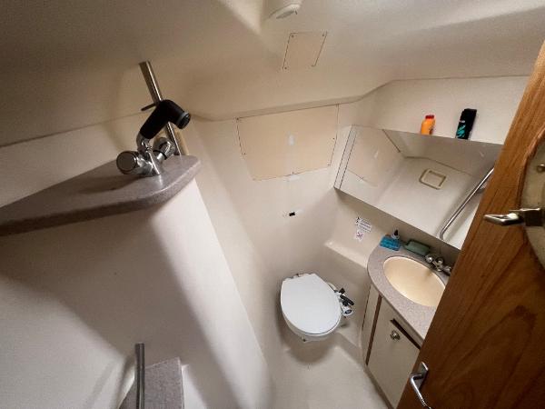 Slide: The Image of Compact bathroom in a 2000 Hunter 410 boat, featuring sink, toilet, and mirror. - 34