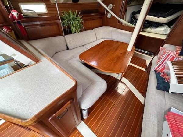 Slide: The Image of 1992 Hunter Legend 37 sailboat interior with wooden table, cushioned seating, and plant. - 20