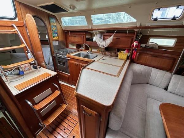 Slide: The Image of 1992 Hunter Legend 37 sailboat interior with kitchen, seating, and wooden cabinetry. - 21