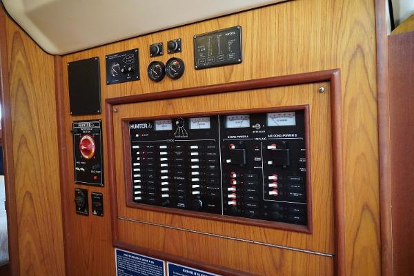 Slide: The Image of Control panel of a 2000 Hunter Passage 420 sailboat, featuring various switches and gauges. - 14
