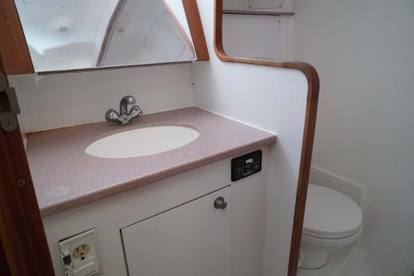 Slide: The Image of Bathroom interior of 2000 Hunter Passage 420 sailboat, featuring sink and toilet. - 25