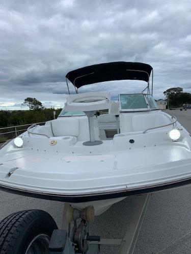 Slide: The Image of 2004 Hurricane 187SD boat with canopy on trailer under cloudy sky. - 1
