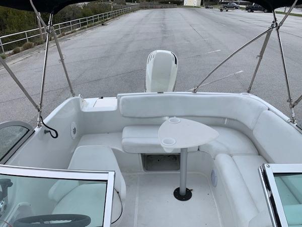 Slide: The Image of 2004 Hurricane 187SD boat interior with white seating and a small table. - 14