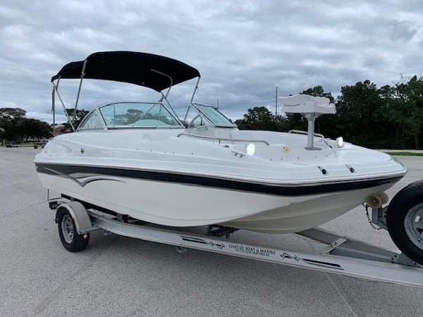 Slide: The Image of 2004 Hurricane 187SD boat on trailer with canopy, parked outdoors. - 9