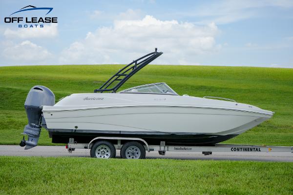 Slide: The Image of 2020 Hurricane 217 SD boat on trailer, green field background, Off Lease Boats logo. - 1