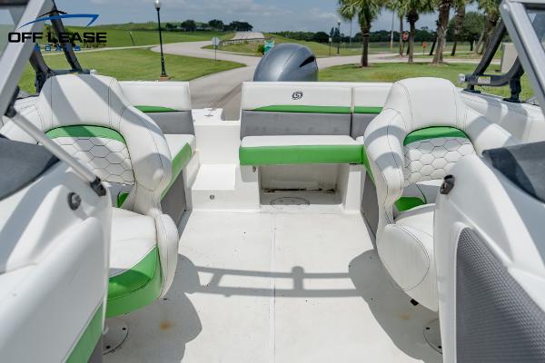 Slide: The Image of 2020 Hurricane 217 SD boat interior with green and white seating, outdoor setting. - 10