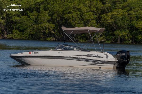 Slide: The Image of 2022 Hurricane 217 SD boat on calm water with lush green background. - 1