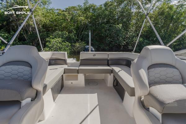 Slide: The Image of 2022 Hurricane 217 SD boat interior with spacious seating and lush greenery in the background. - 10