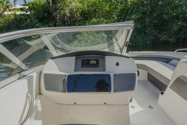 Slide: The Image of 2022 Hurricane 217 SD boat dashboard with clear windshield and lush greenery background. - 8