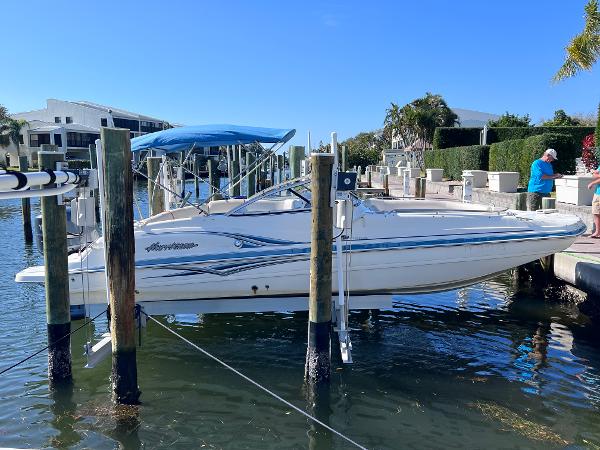 Slide: The Image of 2007 Hurricane 237 Sundeck Yamaha F250 boat docked with blue canopy. - 2