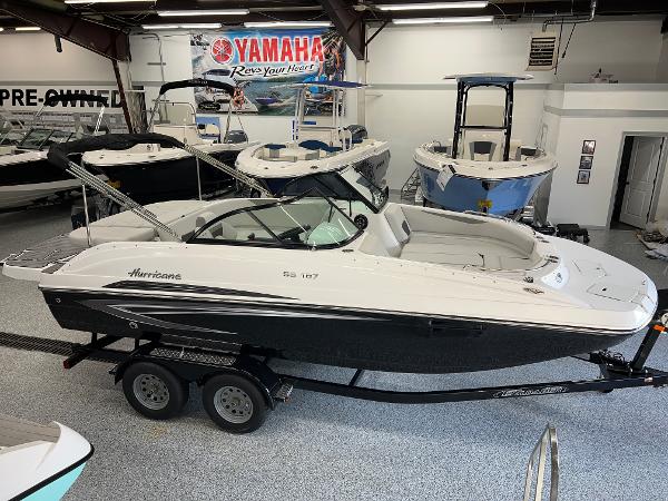 Slide: The Image of 2024 Hurricane SunDeck 187 IO boat displayed in showroom with Yamaha banner. - 0