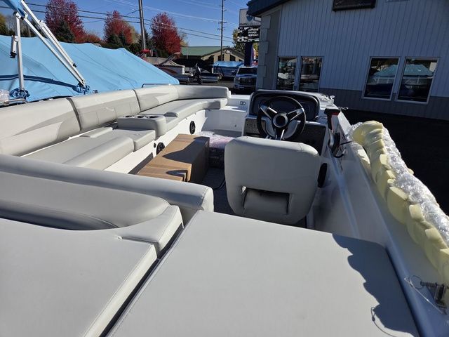 Slide: The Image of 2026 Hurricane SunDeck Sport 201 IO boat interior with seating and steering wheel, parked outdoors. - 3