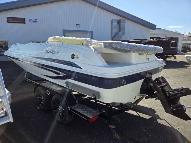 Slide: The Image of 2026 Hurricane SunDeck Sport 201 IO boat on trailer, parked outside a building. - 6