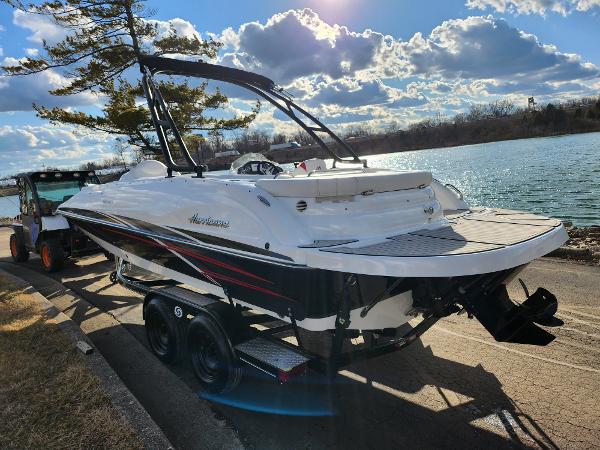Slide: The Image of 2019 Hurricane SunDeck Sport 202 IO boat on trailer by a scenic lake. - 1